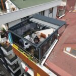 Aplicación de pérgola móvil y balcón de cristal.